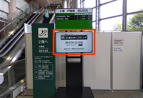 区役所のエスカレーター横に表示される東日本ハウジングの広告